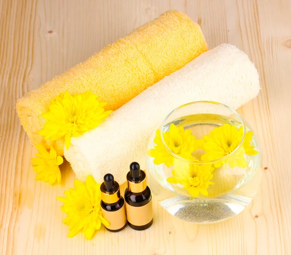 Vaas met gele bloemen, spa instellen op houten achtergrond — Stockfoto