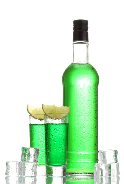 Bottle and glasses of absinthe with lime and ice isolated on white — Stock Photo, Image