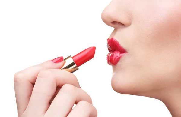 Mooie vrouw is het aanbrengen van haar lippen met rode lippenstift — Stockfoto