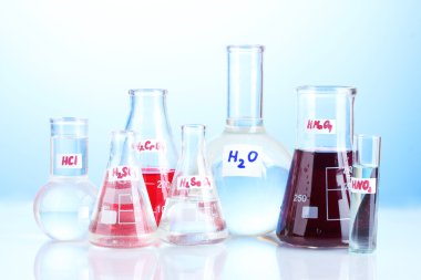 Test-tubes with various acids on blue background clipart