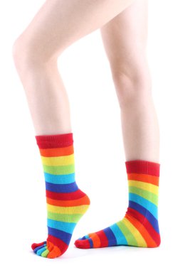 Female legs in colorful striped socks isolated on white clipart