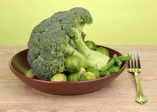 Taze brokoli lahana ve Fransızca fasulye yeşil zemin üzerine ahşap masa üzerinde plaka üzerinde — Stok fotoğraf