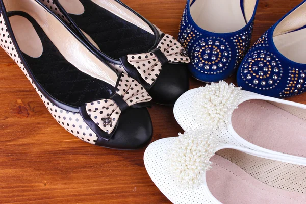 Verschillende paren van vrouwelijke platte schoenen op houten achtergrond — Stockfoto