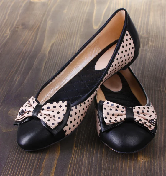 Vrouwelijke platte ballet schoenen patroon met zwarte polka dots op houten achtergrond — Stockfoto