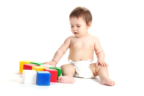 Schattige babymeisje spelen met kubussen geïsoleerd op wit — Stockfoto