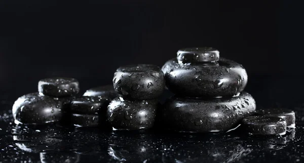 Piedras de spa con gotas sobre fondo negro —  Fotos de Stock