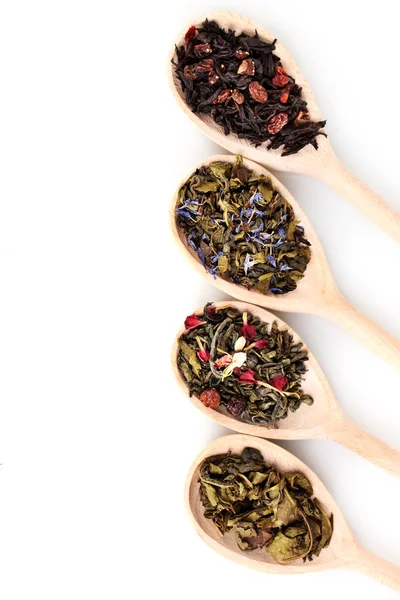 Verschillende droge groene en zwarte thee in houten lepels geïsoleerd op wit — Stockfoto