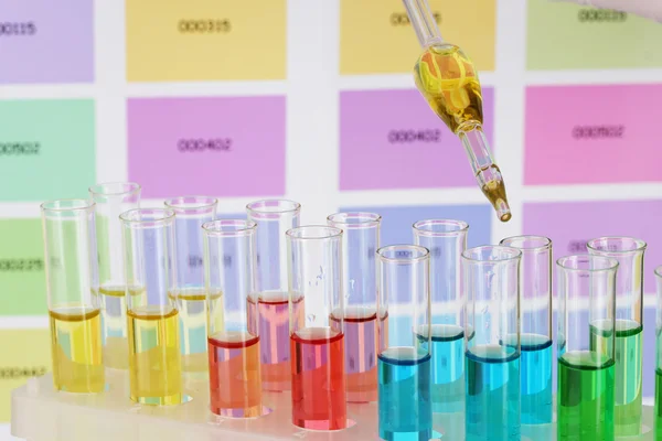 Probówki z kolor płynu i pipety na tle próbek kolorów — Zdjęcie stockowe