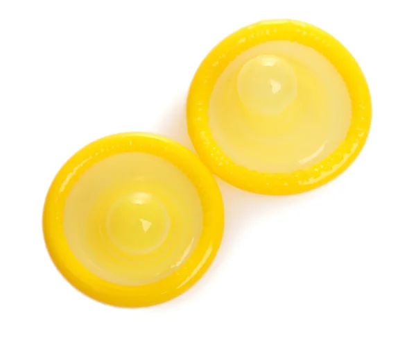 Dvě žluté kondomy izolovaných na bílém — Stock fotografie