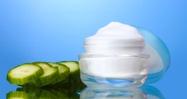 Cream and fresh sliced cucumber on blue background — Stock Photo, Image
