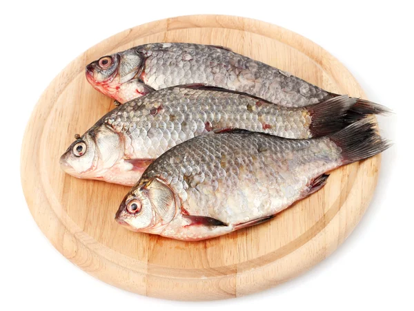 Ahşap kesme tahtası üzerinde beyaz izole üzerinde taze balıklar — Stok fotoğraf