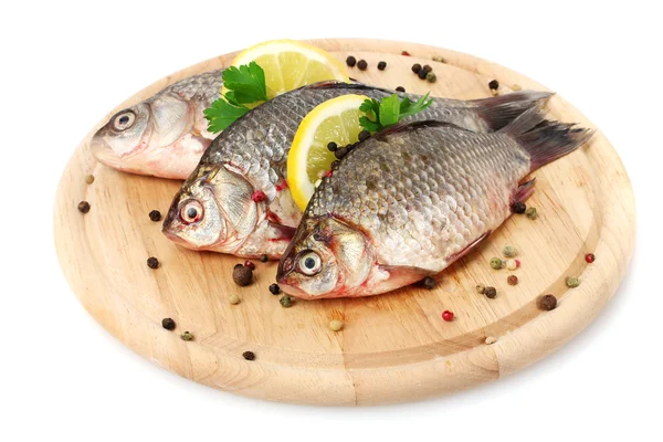 Świeże ryby z cytryny, natki pietruszki i przyprawy na deski do krojenia drewniana na białym tle — Zdjęcie stockowe