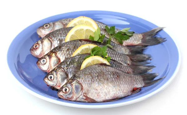 Свежие рыбы с лимоном и петрушкой на тарелке изолированы на белом — стоковое фото