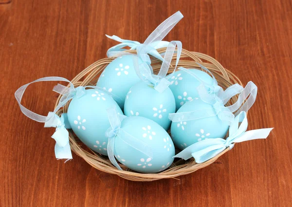 Colorate uova di Pasqua in cesto su sfondo di legno — Foto Stock