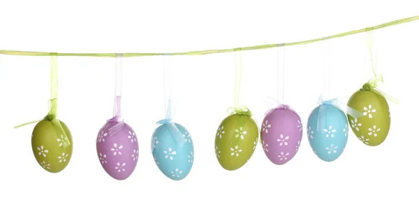 Цветные пасхальные яйца, висящие на лентах, изолированных на белом — стоковое фото