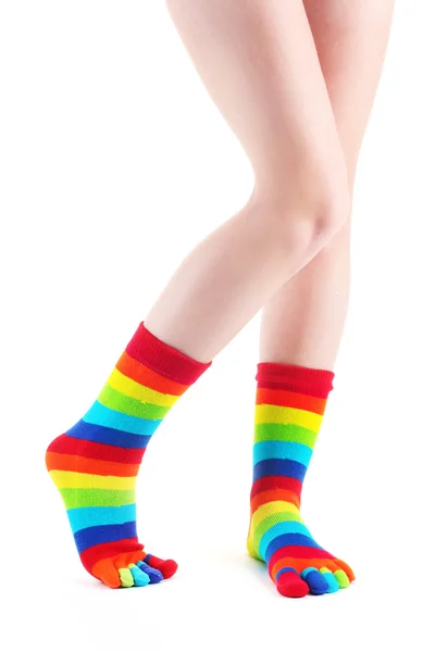 Pernas femininas em meias listradas coloridas isoladas em branco — Fotografia de Stock