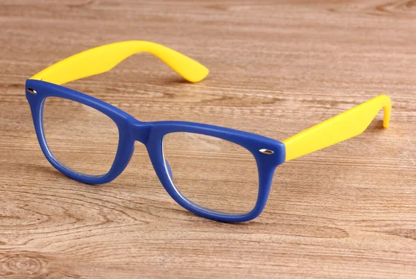Hermosas gafas de color sobre fondo de madera — Foto de Stock