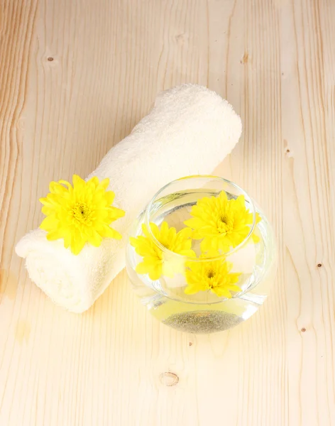 Jarrón con flores amarillas, ajuste de spa sobre fondo de madera — Foto de Stock