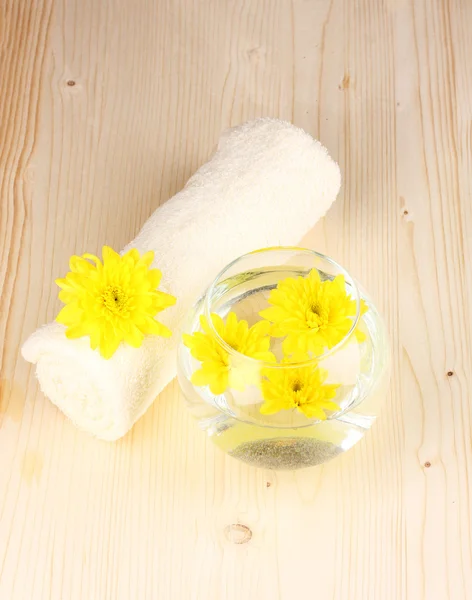 stock image Vase with yellow flowers, spa setting on wooden background