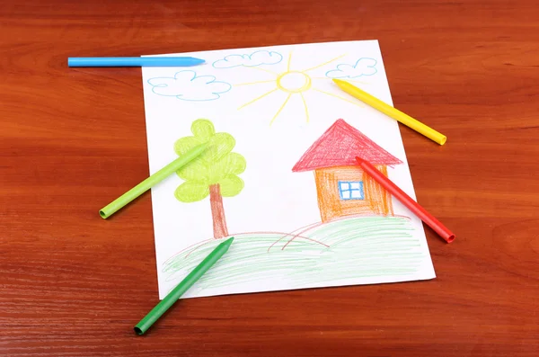 Childrens drawing of house and pencils on wooden background — Stock Photo, Image