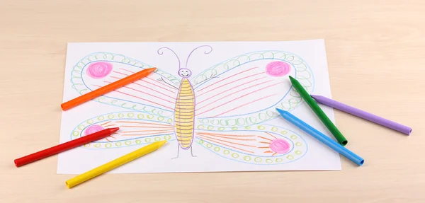 Childrens drawing of butterfly and pencils on wooden background — Stock Photo, Image