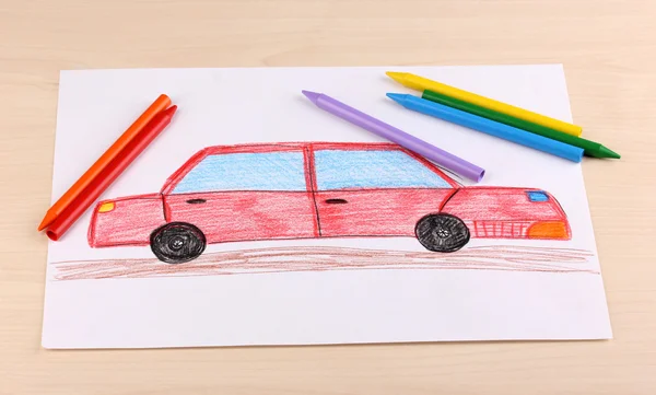 stock image Childrens drawing of red car and pencils on wooden background