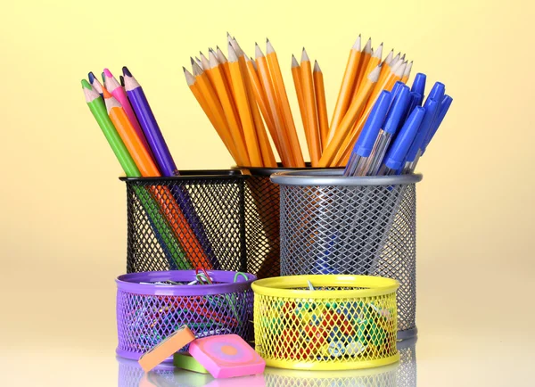 Color holders for office supplies with them on bright background — Zdjęcie stockowe