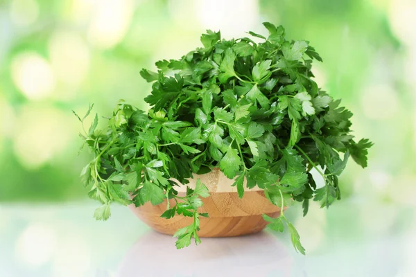 Parsley in a wooden bowl on green background — Stock Photo, Image
