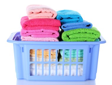 Plastic basket with bright towels isolated on white clipart