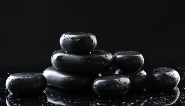 Piedras de spa con gotas sobre fondo negro — Foto de Stock