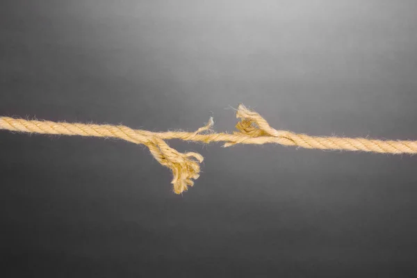 Rompiendo cuerda sobre fondo gris — Foto de Stock