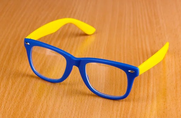 Hermosas gafas de color sobre fondo de madera — Foto de Stock