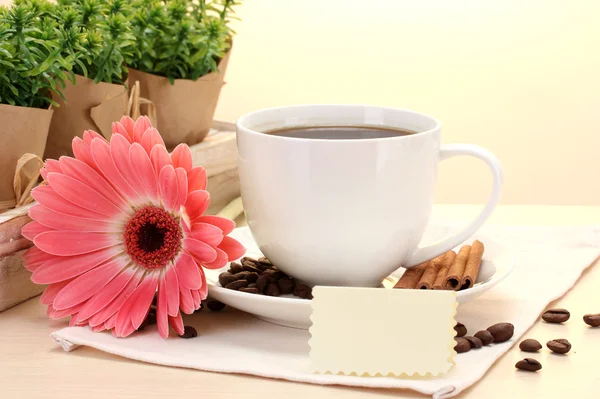 Taza de café y gerberas, palitos de canela en la mesa de madera — Foto de Stock