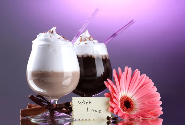 Glasses of coffee cocktail and gerbera flower on violet background — Stock Photo, Image