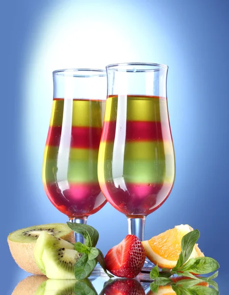 Fruchtgelee in Gläsern und Früchten auf blauem Hintergrund — Stockfoto