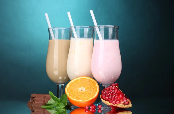 Mléčné koktejly s ovocem a čokoládou na modrém pozadí — Stock fotografie
