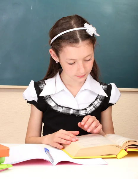 Piccolo scolaro in classe scrivere nel taccuino — Foto Stock