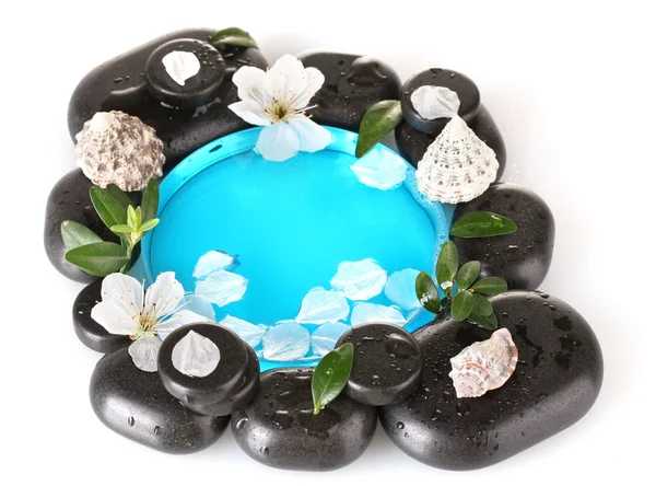 Composizione di pietre termali, acqua blu, petali e foglie isolate su bianco — Foto Stock