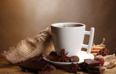 bardak sıcak çikolata, tarçın, fındık ve çikolata kahverengi zemin üzerine ahşap tablo