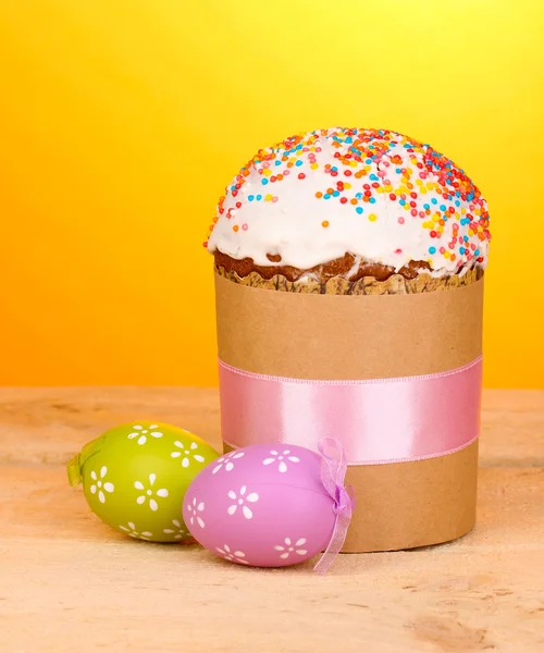 Vackra påsk kaka med ägg på träbord på gul bakgrund — Stockfoto