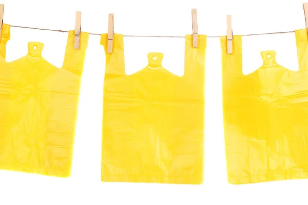 Cellophane bags hanging on rope isolated on white — Stock Photo, Image
