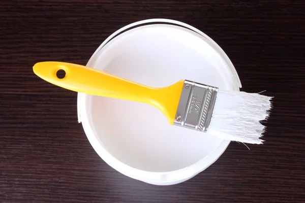 Paint brush and opened can of white paint — Stock Photo, Image
