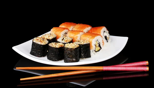 Νόστιμα κυλίνδρους που υπηρέτησε στο λευκό πιάτο με chopsticks απομονώνονται σε μαύρο — Φωτογραφία Αρχείου