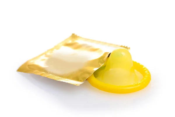 Preservativo amarelo com embalagem aberta isolada sobre branco — Fotografia de Stock