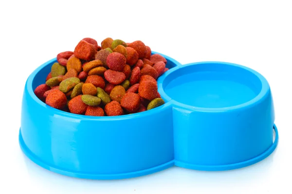 Dry dog food and water in blue bowl isolated on white — Stock Photo, Image