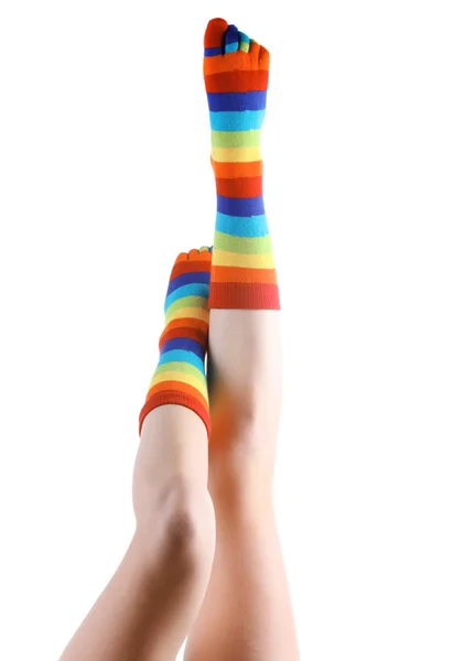 Ženské nohy v barevné pruhované ponožky izolovaných na bílém — Stock fotografie