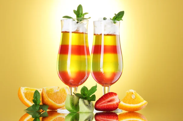 Gelatina de frutas en vasos y frutas sobre fondo amarillo —  Fotos de Stock