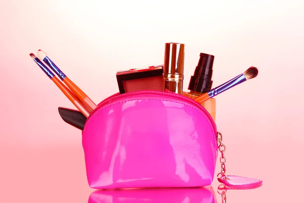 弥补与化妆品和粉红色背景画笔袋 — 图库照片