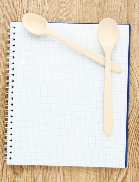 Libro de cocina abierto y utensilios de cocina sobre fondo de madera — Foto de Stock