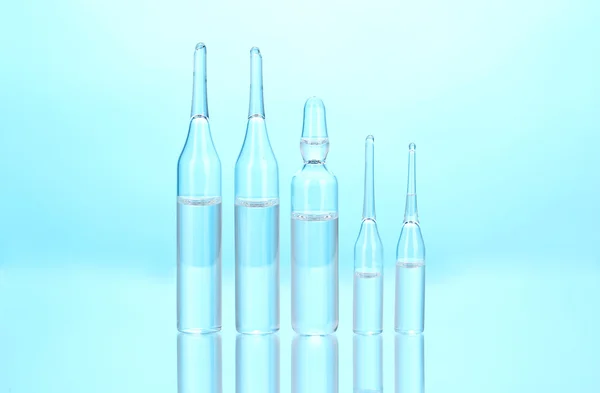 Medical ampoules on blue background — Stock Photo, Image